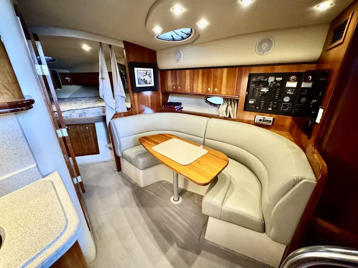  Yacht Photos Pics 2006 Cruisers Yachts 340 Express interior with curved seating and wooden table.