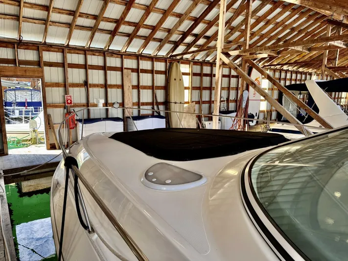  Yacht Photos Pics 2006 Cruisers Yachts 340 Express in a wooden boathouse, partially covered, docked indoors.