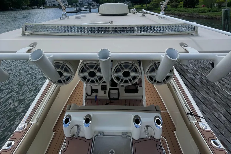  Yacht Photos Pics 2015 Scout 300 LXF boat interior with rod holders and speakers, docked by the water.