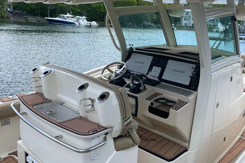 Yacht Photos Pics 2015 Scout 300 LXF boat interior with Garmin navigation system, docked by a serene lake.