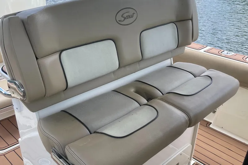  Yacht Photos Pics 2015 Scout 300 LXF boat seat with beige upholstery and logo, on water.