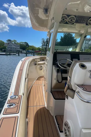  Yacht Photos Pics 2015 Scout 300 LXF boat with sleek design, wooden deck, and modern cockpit on a sunny day.