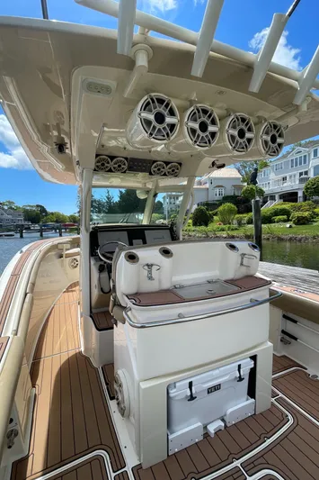  Yacht Photos Pics 2015 Scout 300 LXF boat interior with helm, speakers, and cooler on a sunny day.