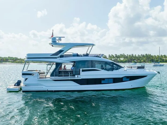  Yacht Photos Pics 2019 Galeon 640 Fly yacht on calm water, featuring sleek design and spacious flybridge.