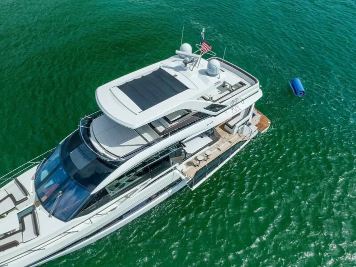  Yacht Photos Pics Aerial view of 2019 Galeon 640 Fly yacht on clear green water.