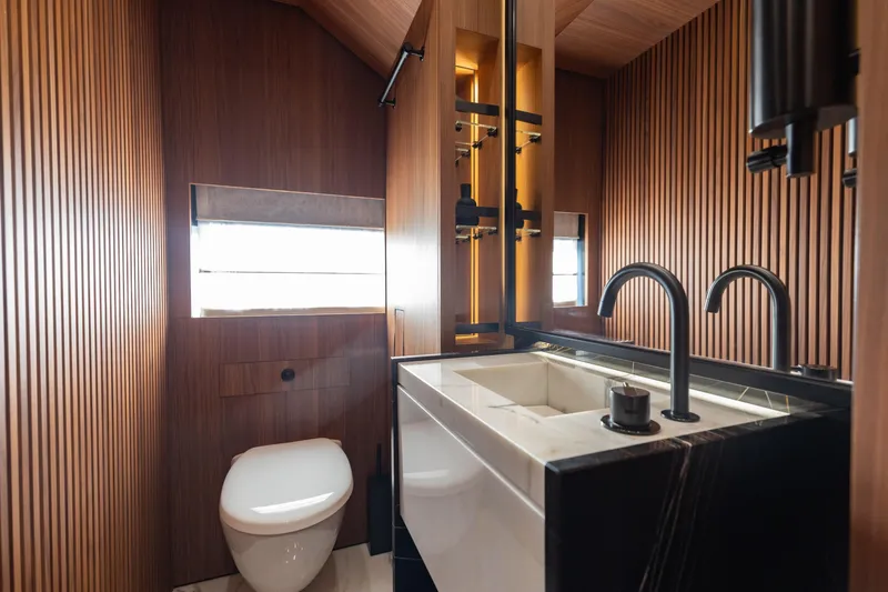 Neverland II Yacht Photos Pics Luxurious bathroom on 2020 Sanlorenzo 44 Alloy yacht with modern fixtures and wood paneling.