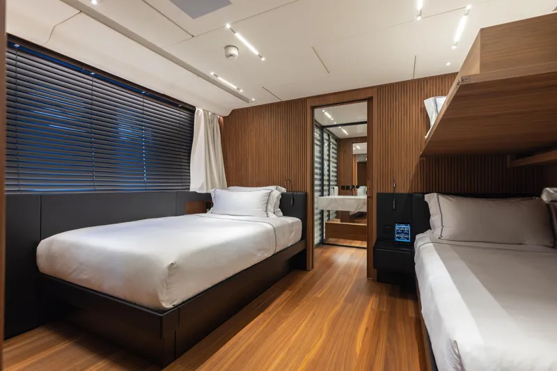 Neverland II Yacht Photos Pics Luxurious Sanlorenzo 44 Alloy 2020 yacht bedroom with modern wood paneling and twin beds.