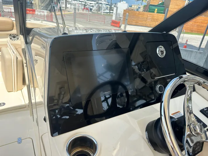  Yacht Photos Pics 2022 Scout 277 Dorado boat dashboard with steering wheel and navigation screen.