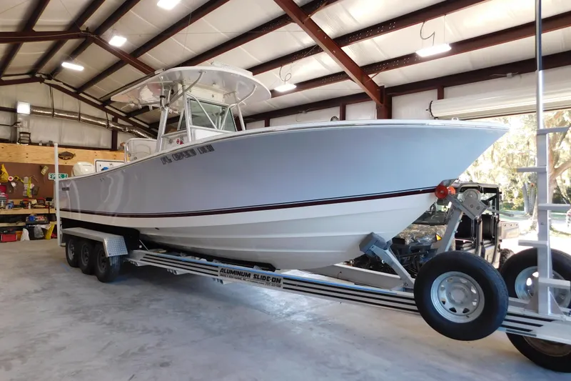  Yacht Photos Pics 2003 Regulator 32 Center Console boat on trailer in a spacious garage.