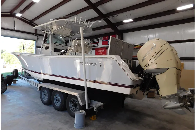  Yacht Photos Pics 2003 Regulator 32 Center Console boat with twin Mercury engines in a garage.