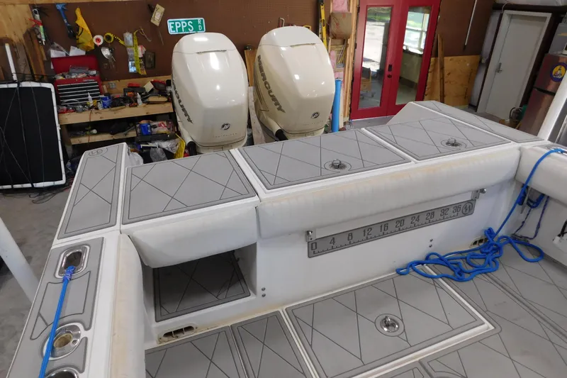  Yacht Photos Pics 2003 Regulator 32 Center Console boat with dual Mercury engines in a workshop setting.