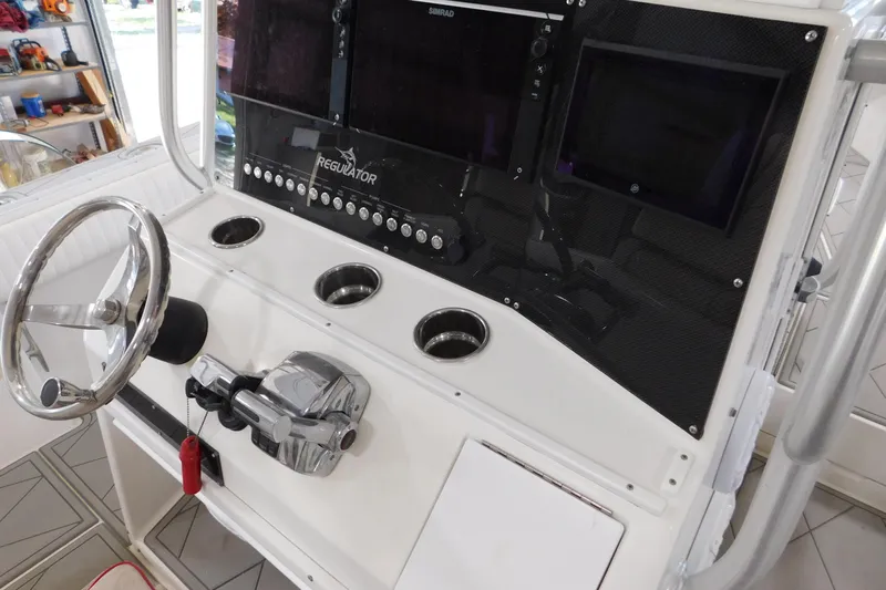  Yacht Photos Pics 2003 Regulator 32 Center Console helm with steering wheel and control panel.