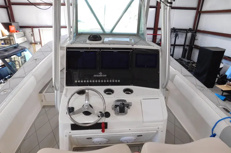  Yacht Photos Pics 2003 Regulator 32 Center Console boat interior with steering wheel and control panel.