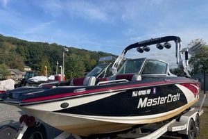 2013 MasterCraft X-25 boat on trailer, parked outdoors under a clear sky.