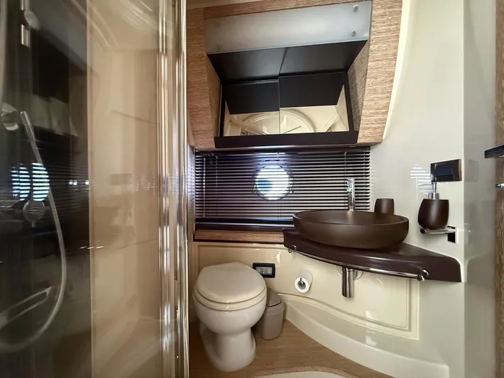  Yacht Photos Pics Luxurious bathroom interior of 2016 Azimut 54 yacht with modern fixtures and porthole window.