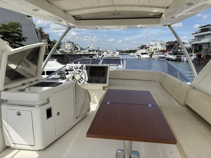  Yacht Photos Pics Flybridge of 2016 Azimut 54 yacht with helm, table, and waterfront view.