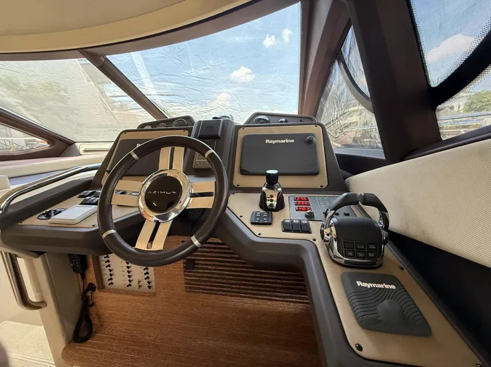  Yacht Photos Pics Cockpit of 2016 Azimut 54 yacht with Raymarine navigation system and steering wheel.