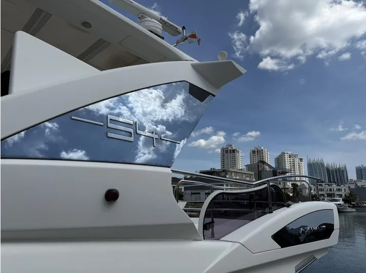  Yacht Photos Pics Luxury Azimut 54 yacht, 2016 model, docked with city skyline and cloudy sky reflection.