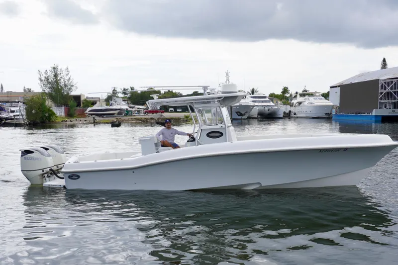  Yacht Photos Pics 2019 Dusky 33 boat on water with Suzuki outboard motor, docked near marina.
