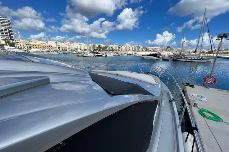 Rivo Co Rivo Yacht Photos Pics 2019 Pershing 5x yacht docked in a marina with cityscape and blue sky.