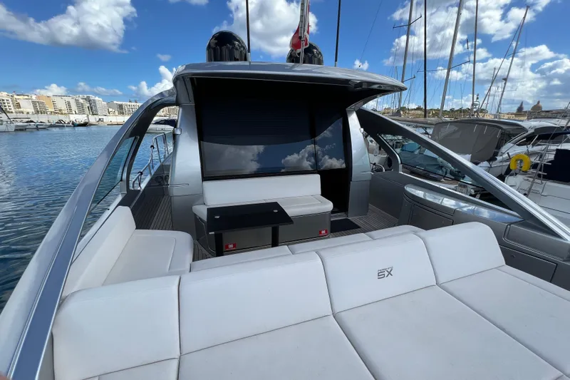Rivo Co Rivo Yacht Photos Pics 2019 Pershing 5x yacht with sleek design, docked in a marina under a blue sky.