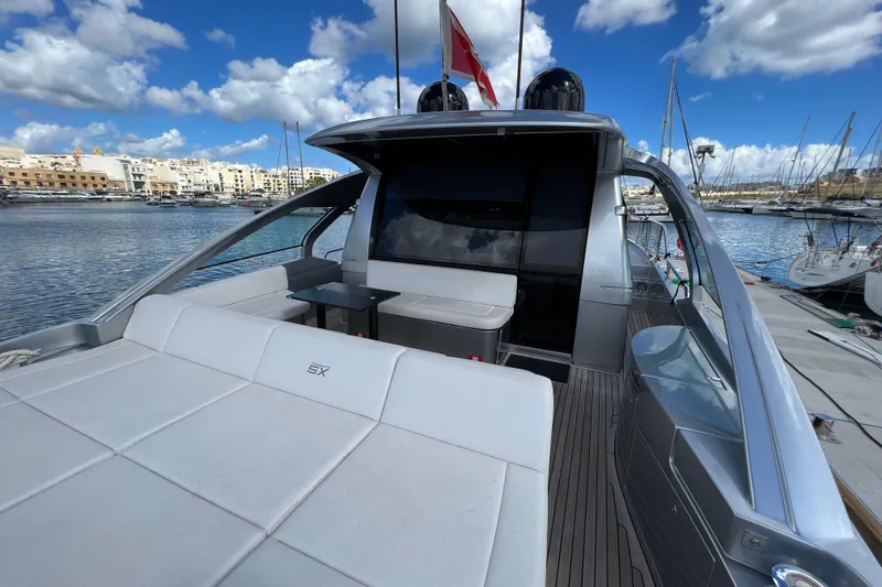 Rivo Co Rivo Yacht Photos Pics 2019 Pershing 5x yacht docked, featuring sleek design and luxurious seating, under a vibrant sky.