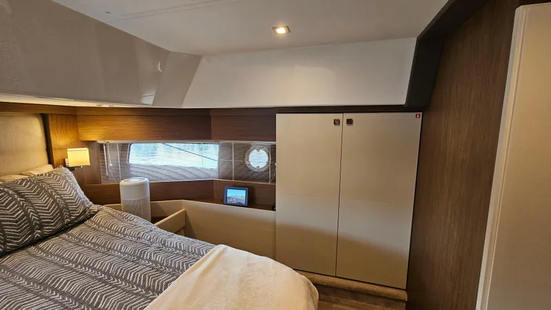  Yacht Photos Pics 2021 Cranchi Eco Trawler T43 cabin interior with bed, wardrobe, and window.