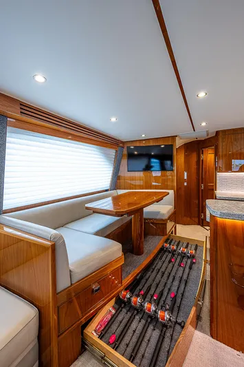 City Hands Yacht Photos Pics Interior of 2020 Viking 68 Convertible yacht with dining area and fishing rod storage.