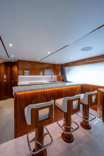 City Hands Yacht Photos Pics Interior of 2020 Viking 68 Convertible yacht with bar stools and wooden finishes.