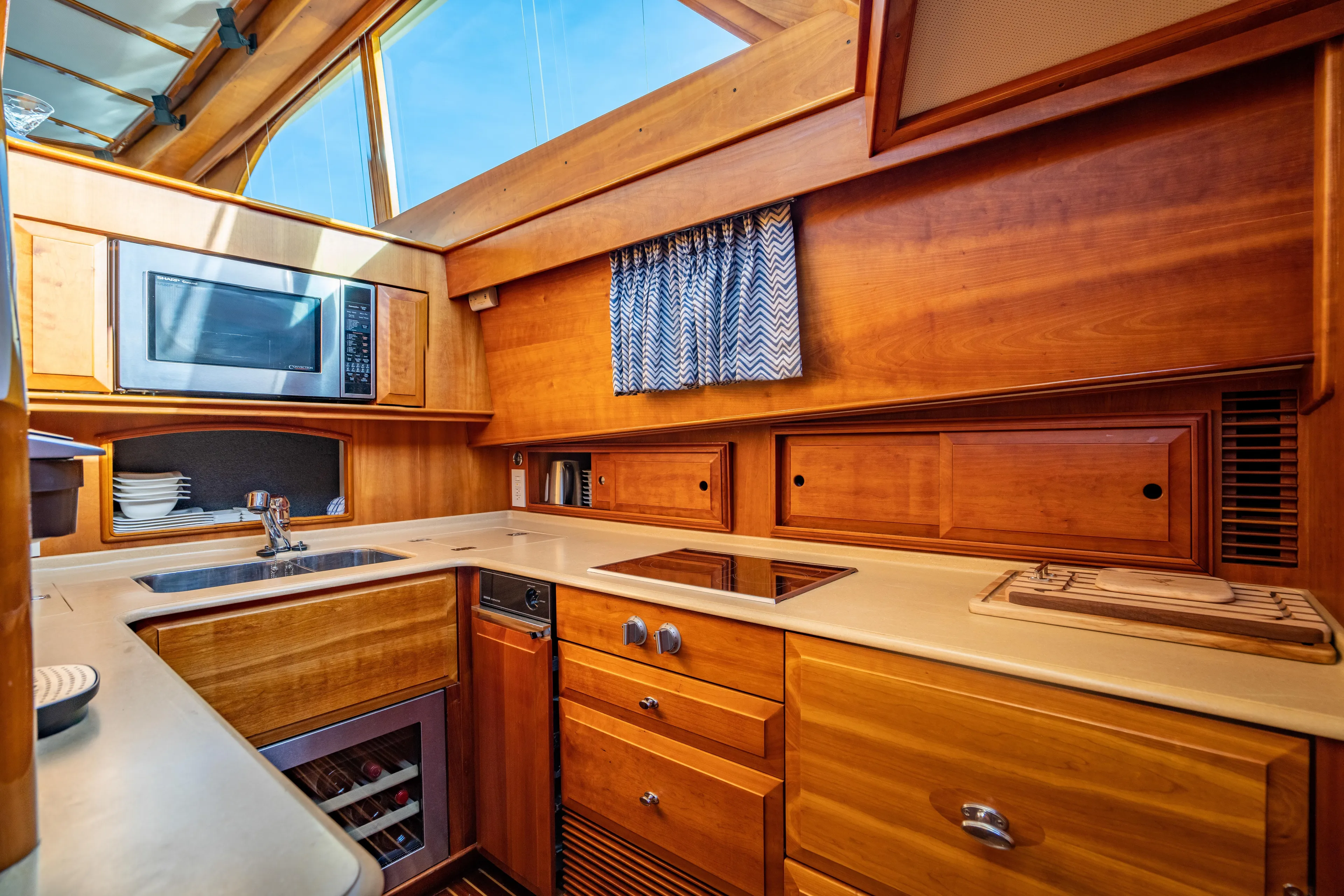 Three Aces Yacht Photos Pics Luxurious 2007 Hinckley Talaria 55 FB yacht kitchen with wood cabinetry and modern appliances.