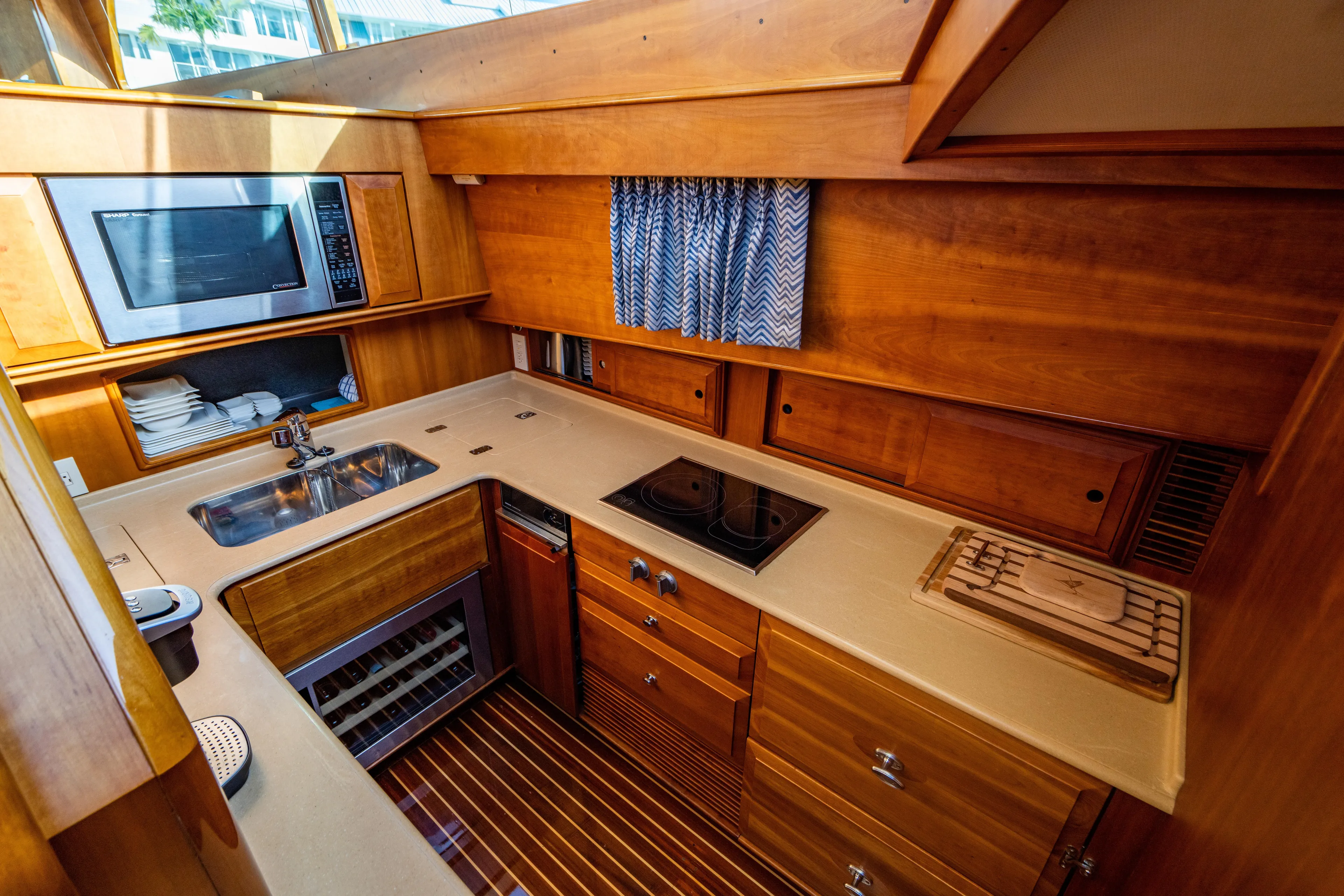 Three Aces Yacht Photos Pics 2007 Hinckley Talaria 55 FB yacht kitchen with wood cabinetry, sink, stove, and microwave.