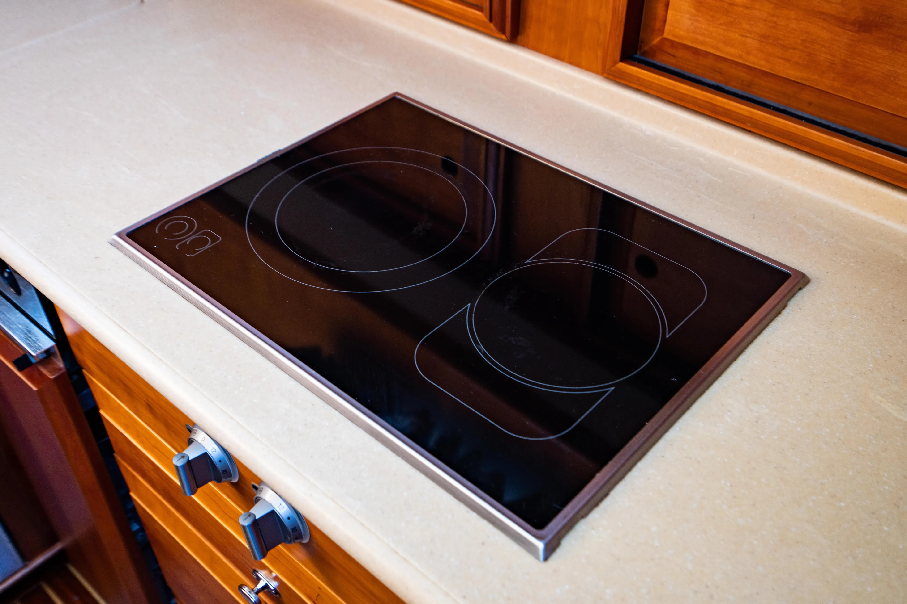 Three Aces Yacht Photos Pics Glass cooktop on Hinckley Talaria 55 FB yacht, 2007 model, with wooden cabinetry.