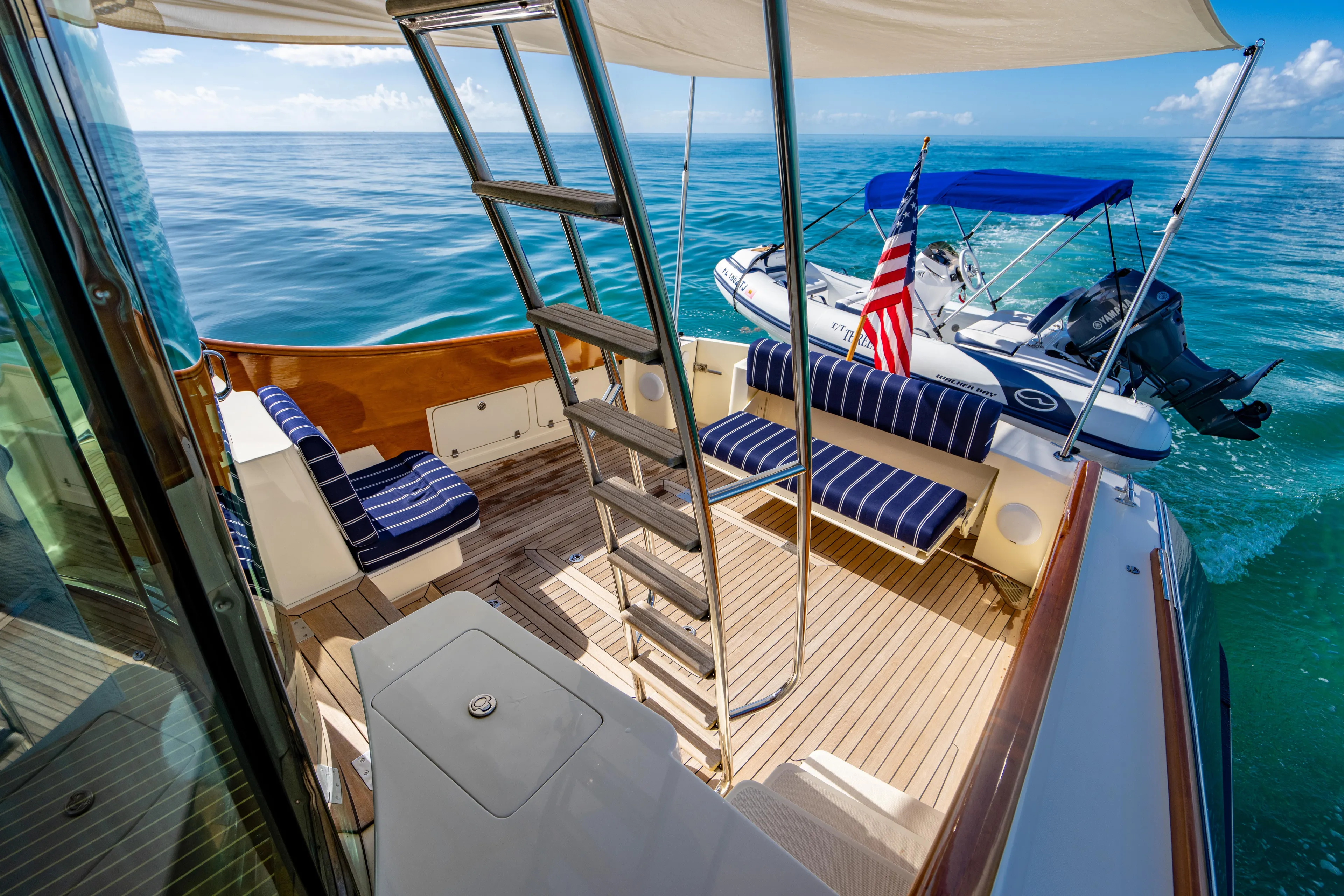 Three Aces Yacht Photos Pics 2007 Hinckley Talaria 55 FB yacht deck with seating, ladder, and small boat.