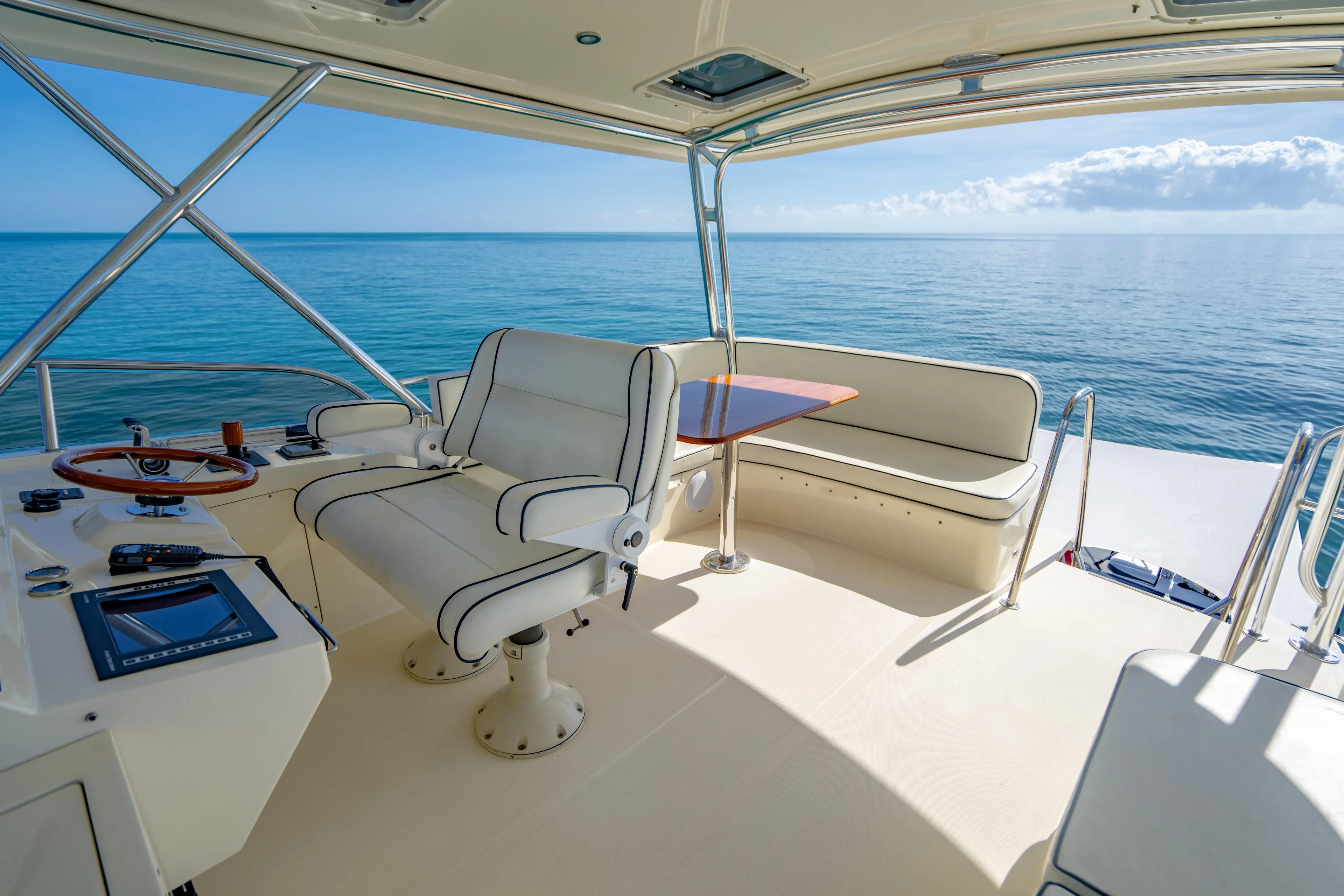 Three Aces Yacht Photos Pics 2007 Hinckley Talaria 55 FB yacht helm with ocean view, featuring luxurious seating and navigation controls.