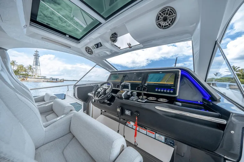 Yacht Photos Pics 2025 Azimut Verve 48 yacht cockpit with modern controls and scenic lighthouse view.