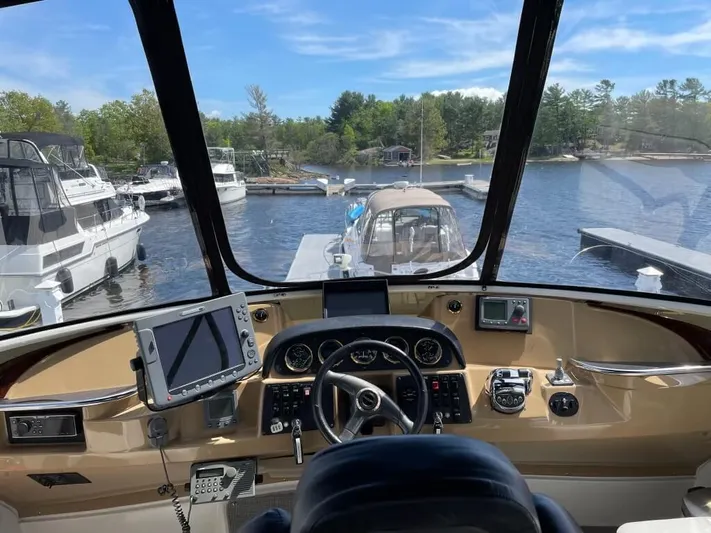  Yacht Photos Pics 2001 Carver 444 Cockpit Motor Yacht helm with navigation equipment, docked at a scenic marina.