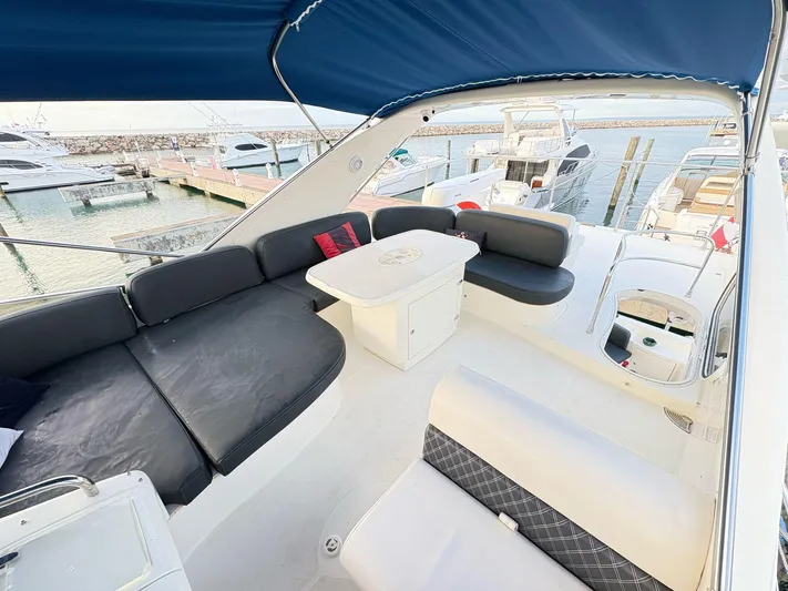  Yacht Photos Pics Azimut 62 Flybridge 2004 yacht interior with seating and table, docked at marina.