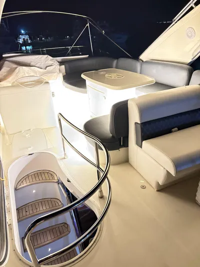  Yacht Photos Pics Luxurious 2004 Azimut 62 Flybridge yacht interior with elegant seating and table at night.