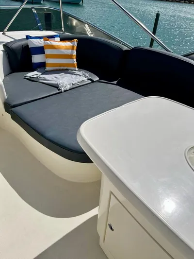  Yacht Photos Pics 2004 Azimut 62 Flybridge yacht with cushioned seating and striped pillows on deck.