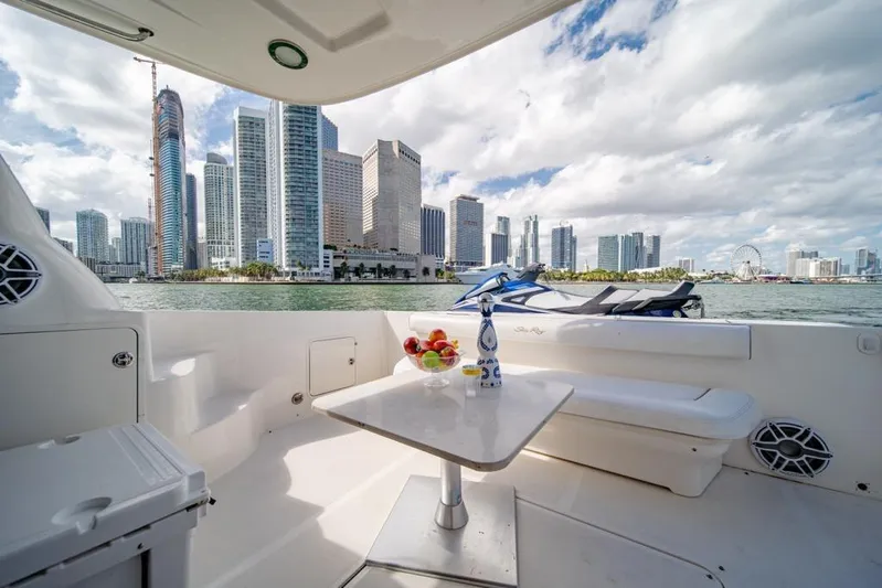  Yacht Photos Pics 2006 Sea Ray 52 Sedan Bridge yacht with city skyline view, featuring a table and seating area.