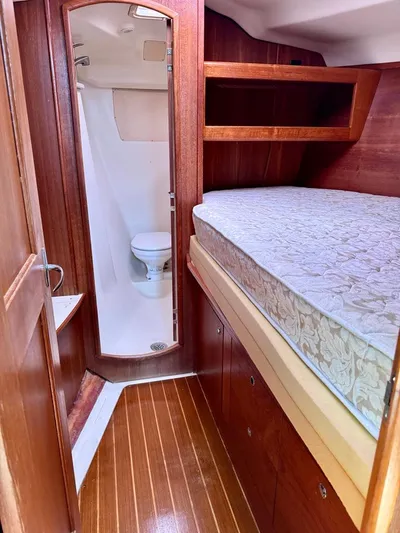 Gypsy Palace Yacht Photos Pics 2003 Hunter Passage 420 yacht interior with wooden finish, bed, and compact bathroom.