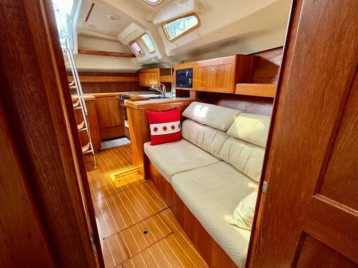 Gypsy Palace Yacht Photos Pics Interior of 2003 Hunter Passage 420 yacht with cozy seating and wooden cabinetry.