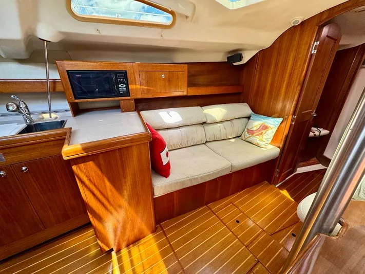 Gypsy Palace Yacht Photos Pics Interior of 2003 Hunter Passage 420 yacht with cozy seating and wooden cabinetry.