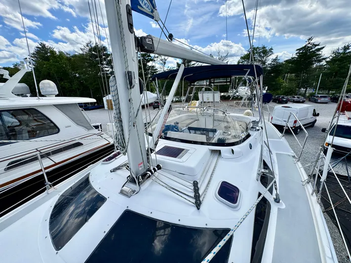 Gypsy Palace Yacht Photos Pics 2003 Hunter Passage 420 sailboat docked, showcasing deck and mast under a partly cloudy sky.