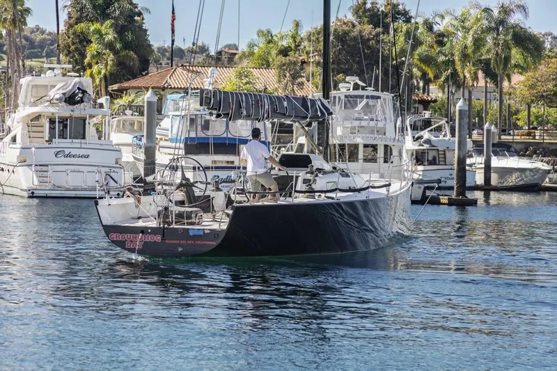 Ground Hog Day Yacht Photos Pics Sailboat "Groundhog Day" in marina, Rogers 46 model, 2007, surrounded by yachts and palm trees.