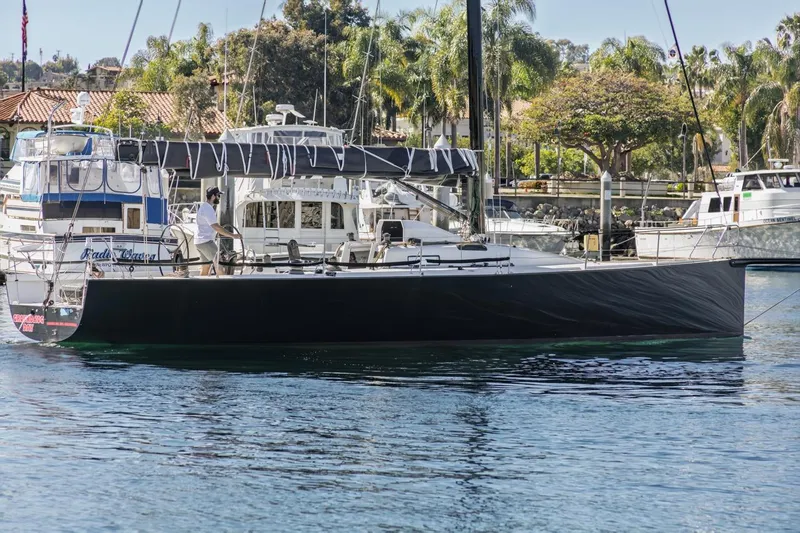 Ground Hog Day Yacht Photos Pics Sleek 2007 Rogers 46 sailboat docked in a marina with palm trees in the background.