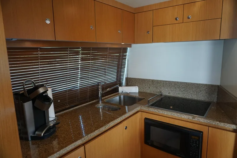 Motor Mile Marine Yacht Photos Pics Kitchen area in a 2008 Ferretti Yachts 630 with modern appliances and wooden cabinetry.