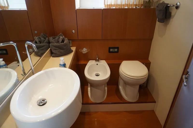 Motor Mile Marine Yacht Photos Pics Luxurious bathroom in 2008 Ferretti Yachts 630, featuring modern sink, bidet, and toilet.