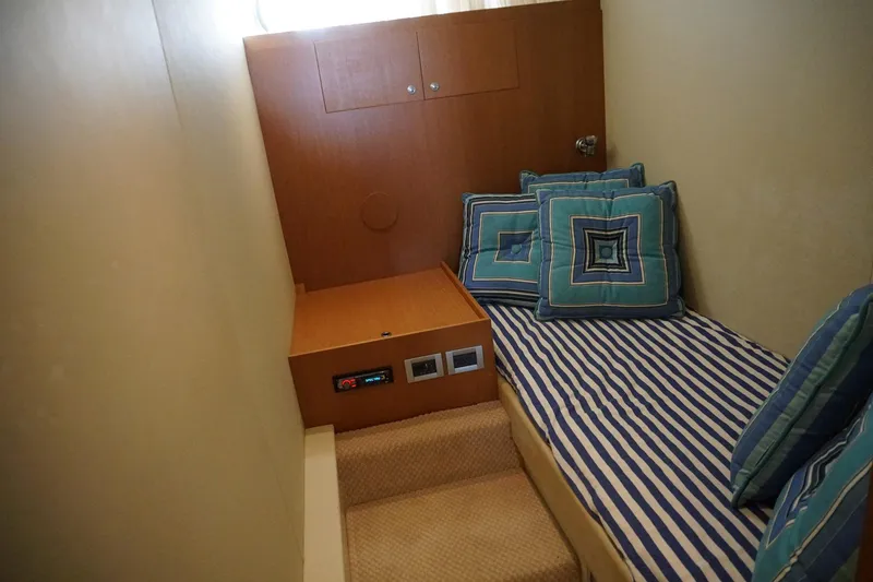 Motor Mile Marine Yacht Photos Pics Cozy cabin interior of 2008 Ferretti Yachts 630 with striped bedding and decorative pillows.