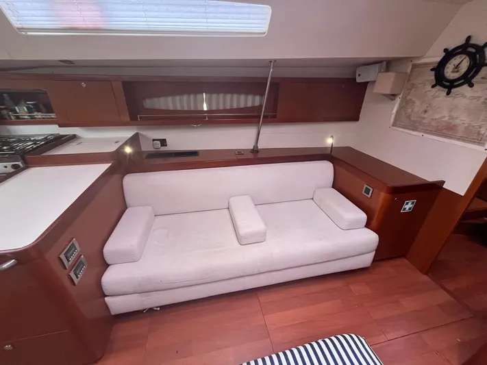 Freedom Yacht Photos Pics Interior of 2011 Beneteau Oceanis 58 yacht with white sofa and wooden cabinetry.